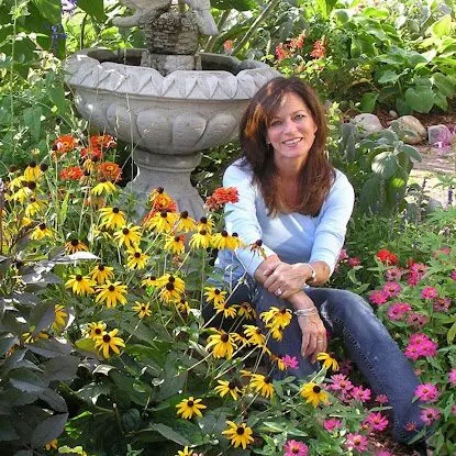 A woman sitting in the middle of some flowers
